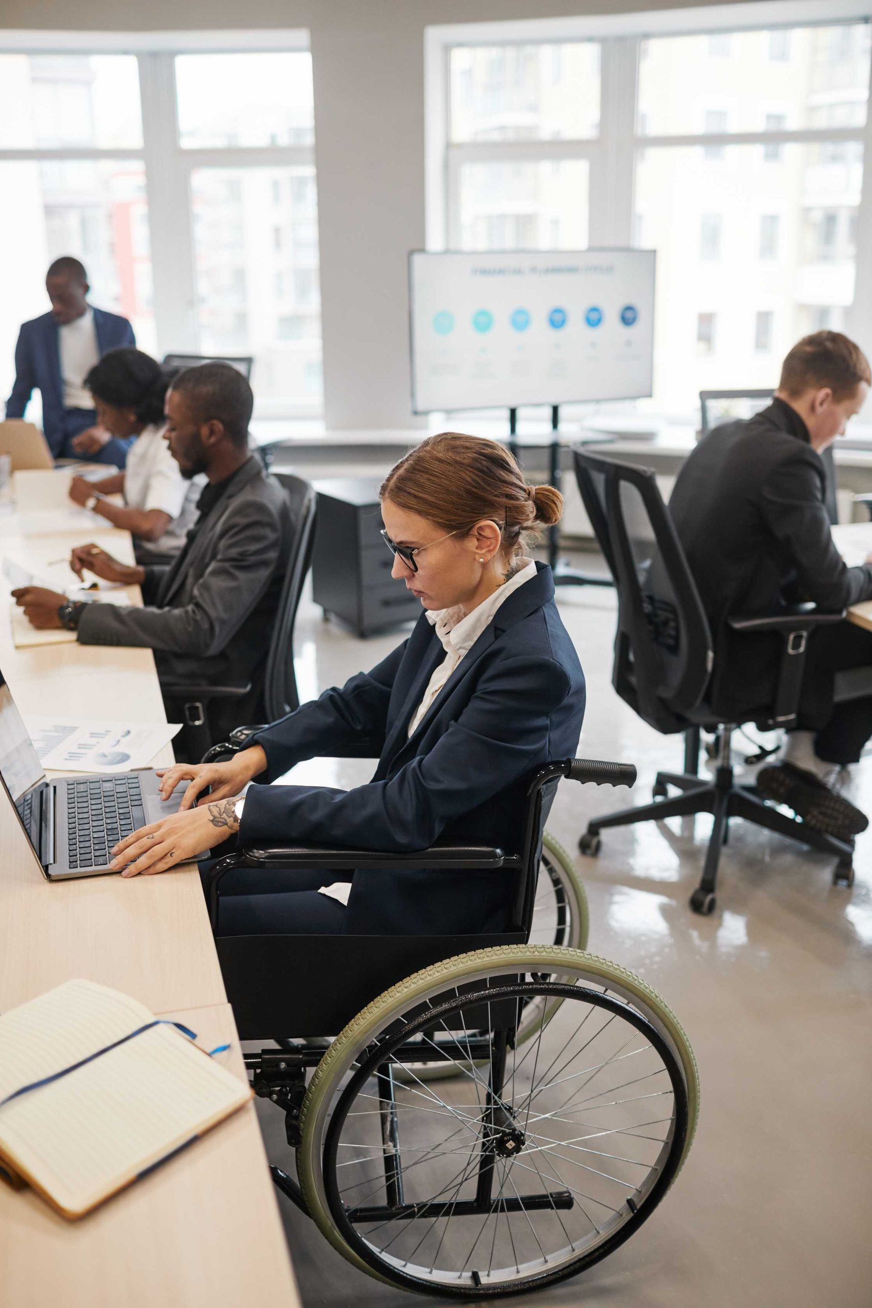 woman-in-wheelchair-working-in-office-vertical-2026-01-11-11-12-11-utc